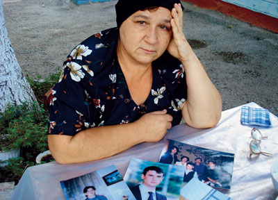 Русская учительница Вера Драганчук держит фотографии убитых неизвестными членов своей семьи
